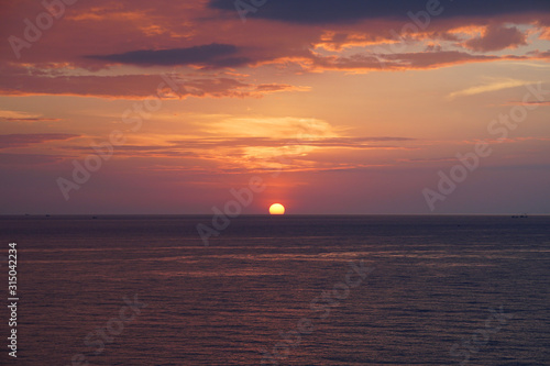 Nature seascape of Tranquil sunset scene. Sun and dark clouds with twilight sky over the sea at phuket Thailand - image Travel nature backdrop background and copy space                           