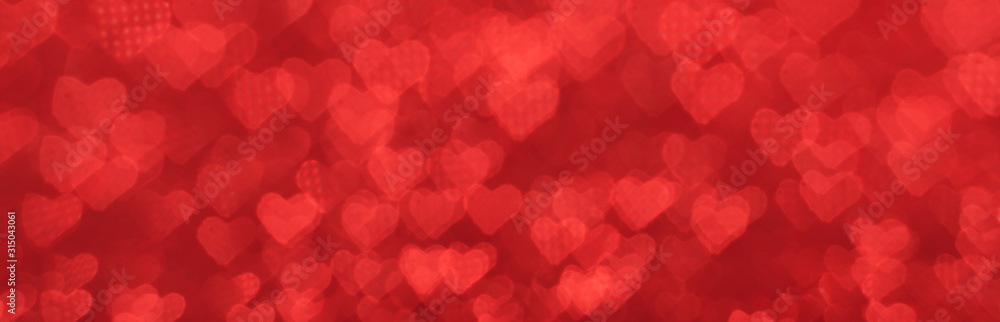 The bokeh texture in the form of many small hearts on a red background. The bokeh texture in the form of many small hearts on a red background.