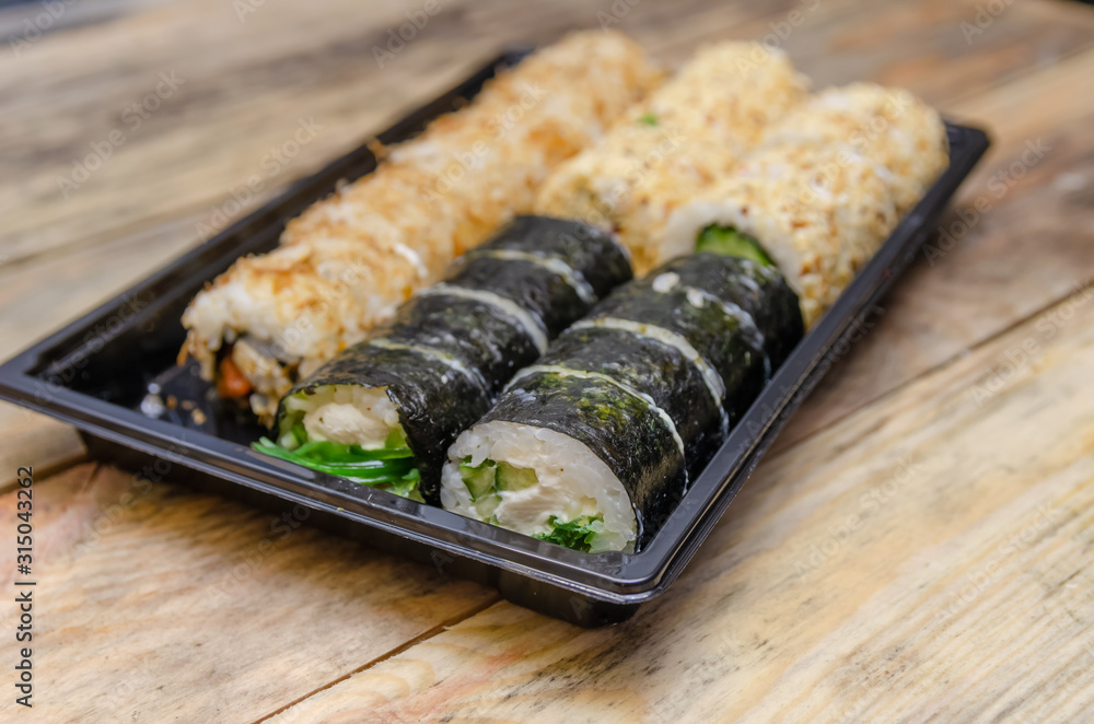 Set sushi Toto Maki, Bonito Maki, Akito Maki on a wooden background. Top view, side view Set sushi Toto Maki, Bonito Maki, Akito Maki on a wooden background. Top view, side view