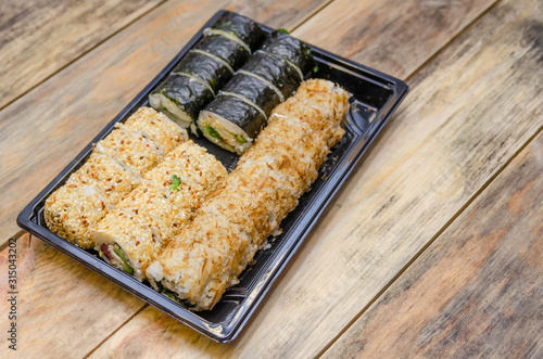 Set sushi Toto Maki, Bonito Maki, Akito Maki on a wooden background. Top view, side view