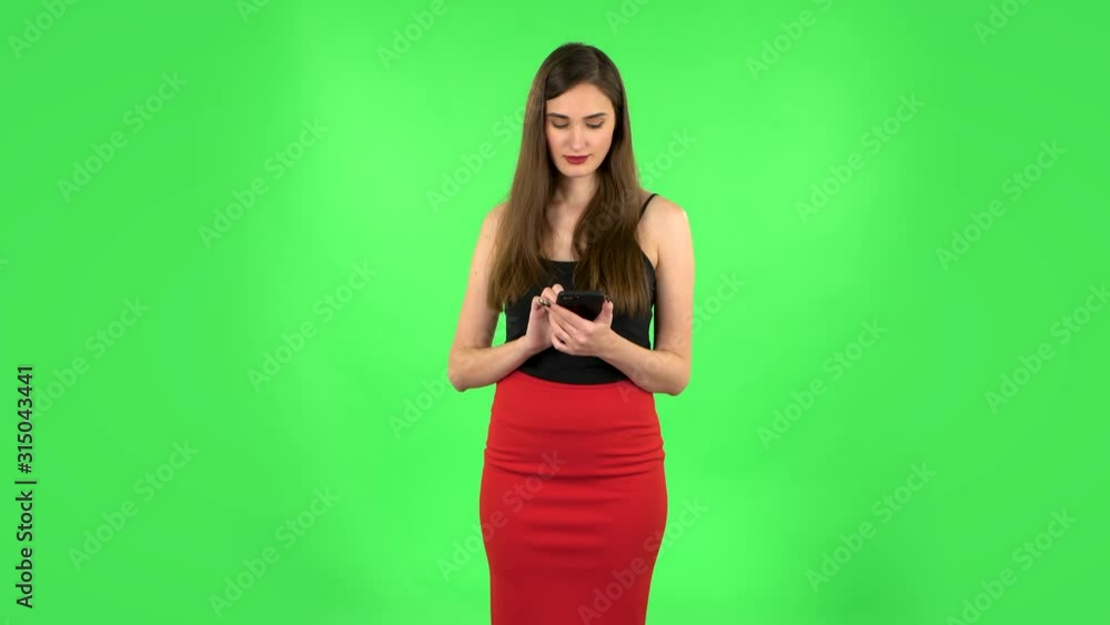 Young woman texting on her phone. Green screen Young woman texting on her phone. Green screen