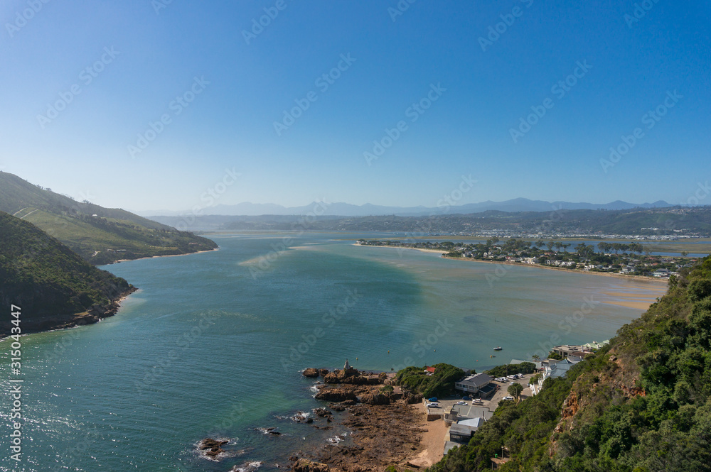 Fototapeta premium Aerial view of Knysna lagoon with forest covered mountains