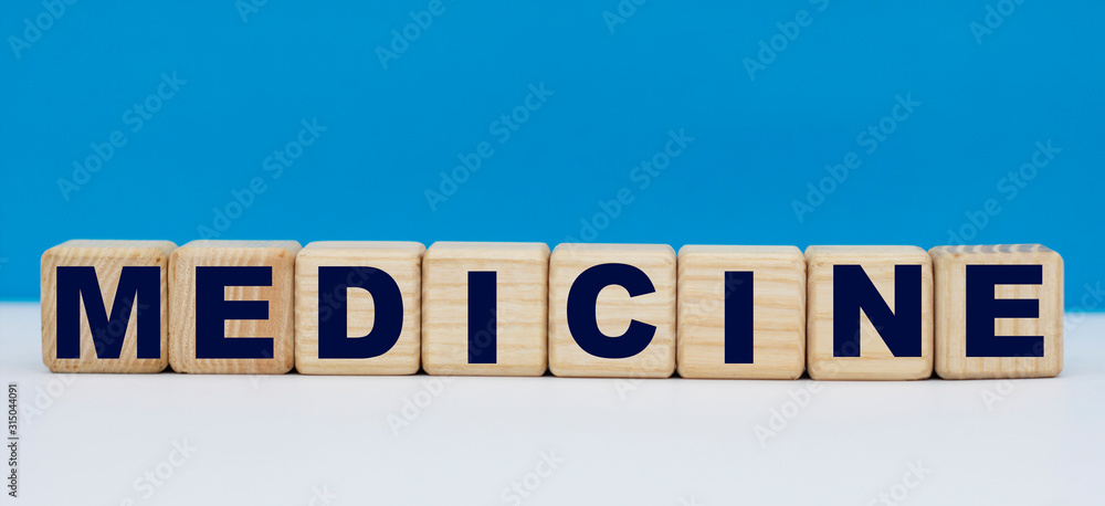 concept word medicine on wooden cubes on a blue background