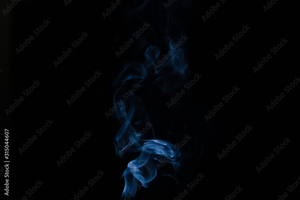 Beautiful abstract blue smoke with copy space on black background. Smoke background for art design or drawing. Abstract figure of the smoke Beautiful abstract blue smoke with copy space on black background. Smoke background for art design or drawing. Abstract figure of the smoke