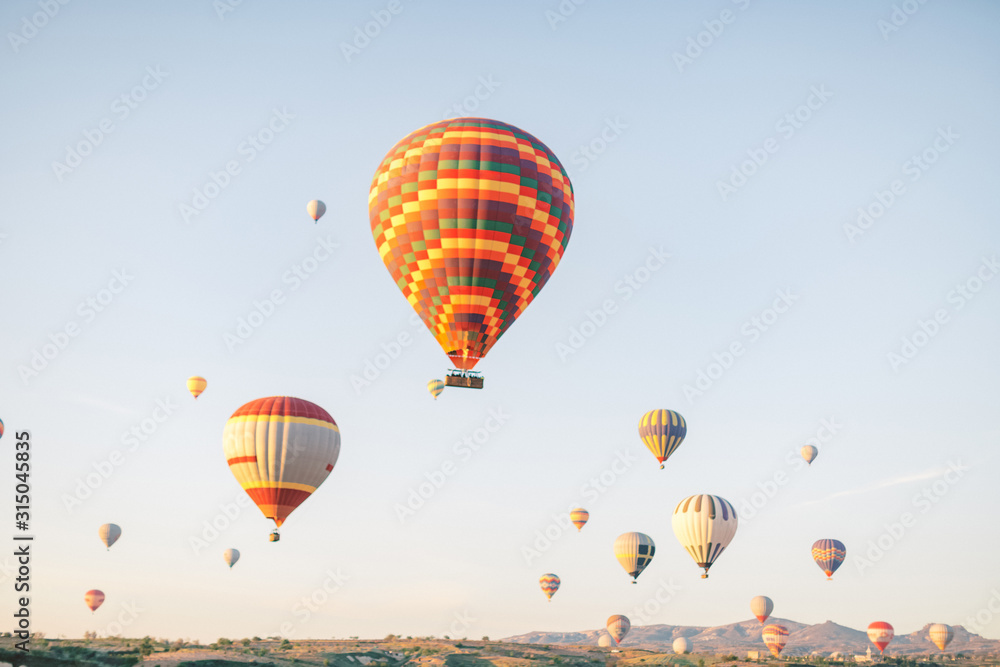 Fototapeta premium Colorful hot air balloons flying over the valley in Cappadocia, Turkey