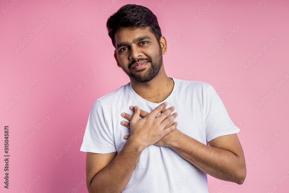 Portrait of handsome Indian guy standing on pink background Portrait of handsome Indian guy standing on pink background