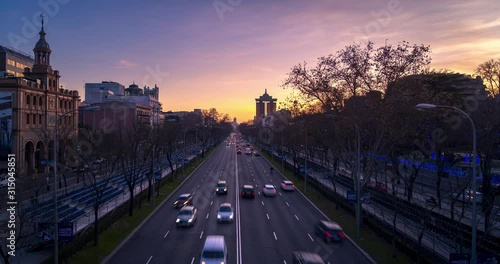 Aerial view of the Paseo de la Castellana in  Madrid, Spain. Day to night Time lapse and beautiful sunset with traffic passing below the camera. photo