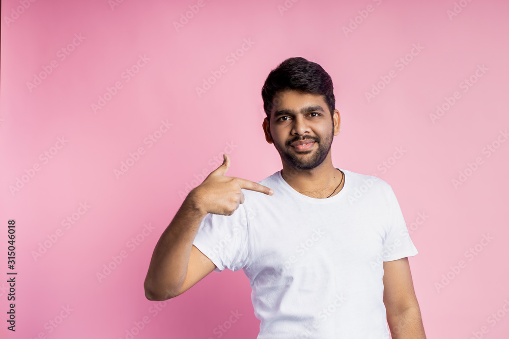 Portrait of handsome Indian guy standing on pink background Portrait of handsome Indian guy standing on pink background