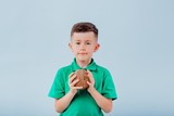 boy with coconut in hand. isolated on blue background, copy space, in studio,