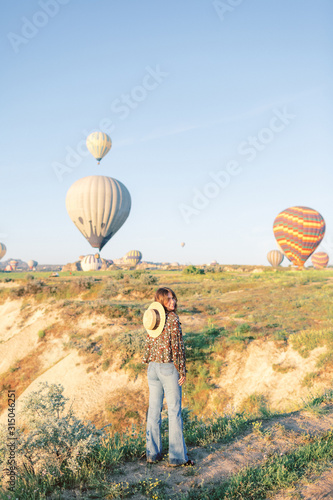Woman tourist. Woman watching colorful hot air balloons flying over the valley at Cappadocia, Turkey