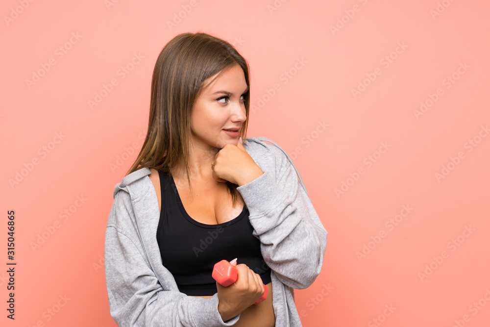 Teenager sport girl making weightlifting over isolated pink background thinking an idea and looking side Teenager sport girl making weightlifting over isolated pink background thinking an idea and looking side