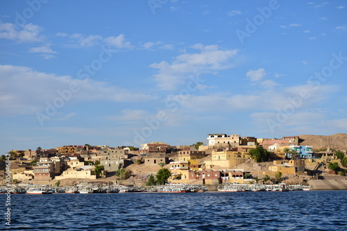 Fototapeta Naklejka Na Ścianę i Meble -  River Nile/ beautiful view for Aswan Egypt and Nubian Egyptian culture. sailing boat sailing in the River Nile and harbor with birds and local houses on the 2 sides 