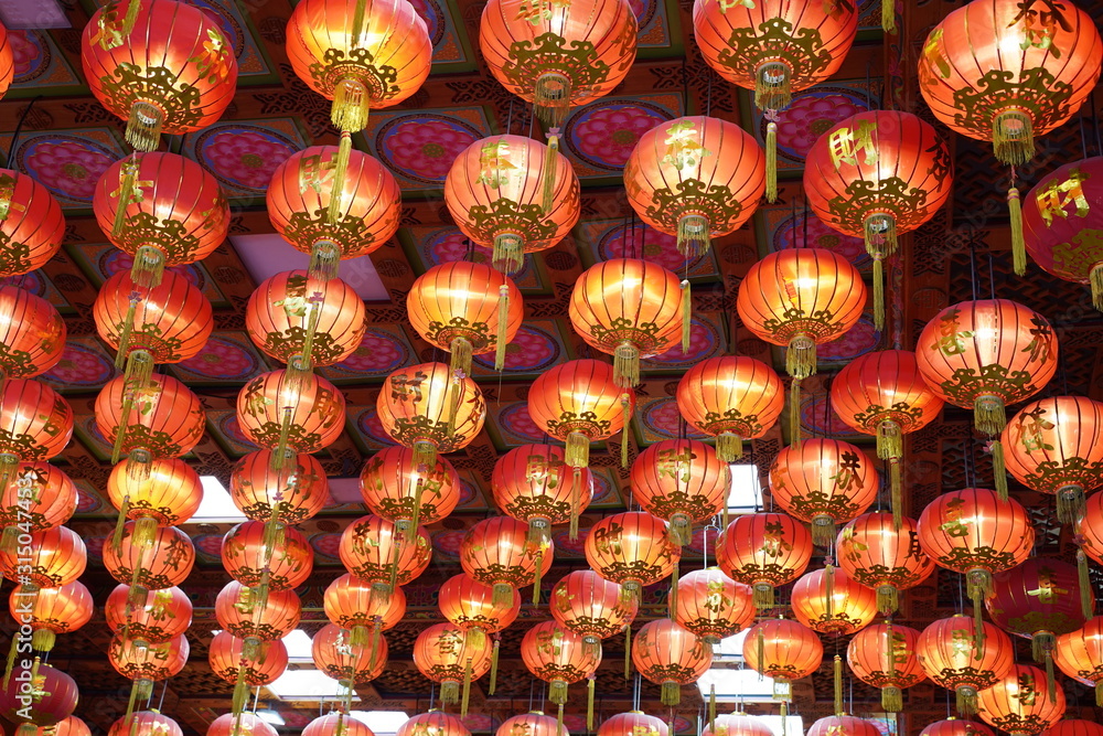 Many illuminated red Chinese lanterns with some Chinese characters on it in temple - Used across countries in Asia for celebrating Chinese New Year tradition Many illuminated red Chinese lanterns with some Chinese characters on it in temple - Used across countries in Asia for celebrating Chinese New Year tradition