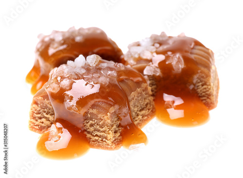 Delicious salted caramel with sauce on white background
