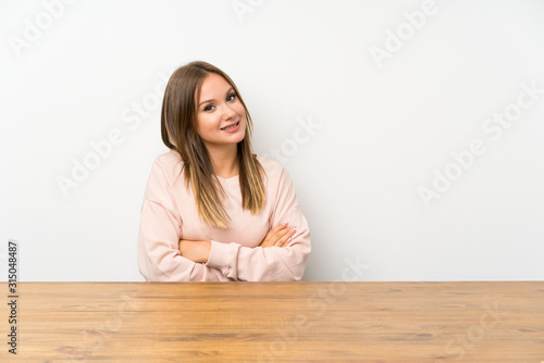 Teenager girl in a table laughing