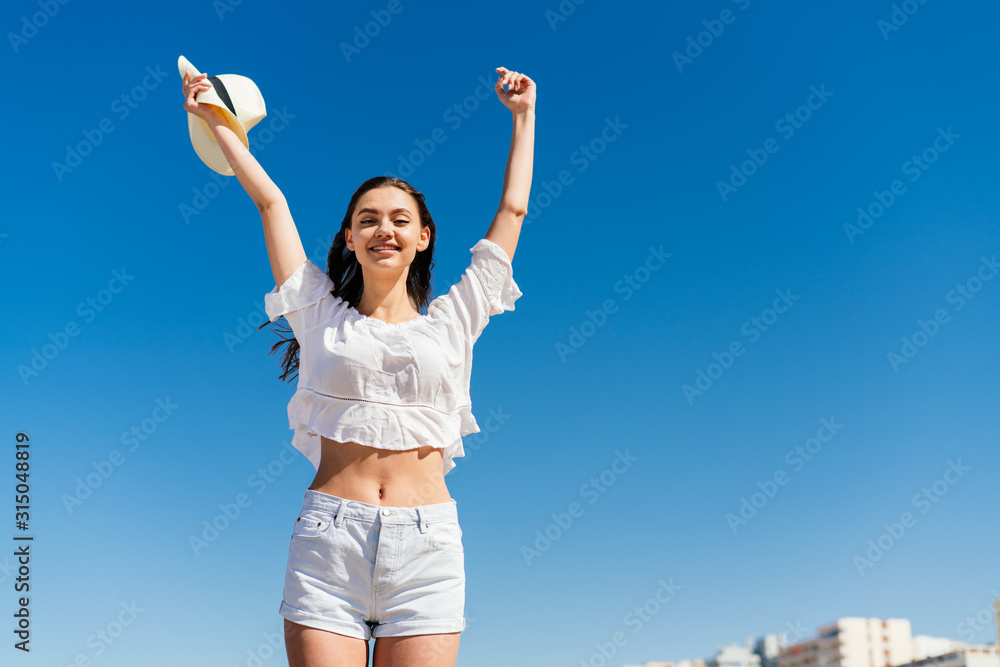 a girl with an emotion of sincere joy on her face triumphantly threw both hands up against the blue sky a girl with an emotion of sincere joy on her face triumphantly threw both hands up against the blue sky