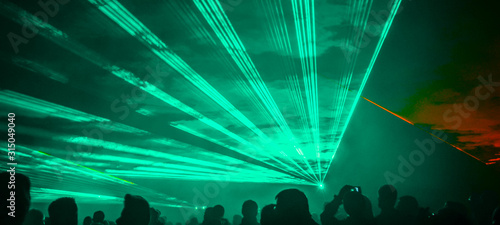 Картината върху платно colorful outdoor laser show with silhouette of people