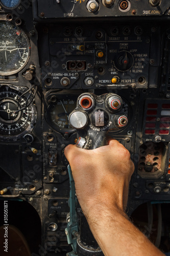 Pilot's hand on the military aircraft control knob. In the cockpit of an old, Soviet military jet. Close-up. Text translation from Russian "pitching nose up"