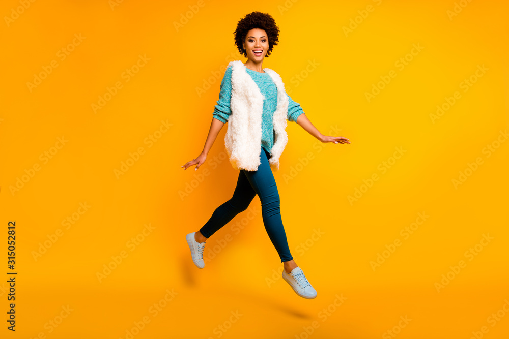 Full size photo of cheerful afro american girl jump rest relax go walk feel dreamy emotions wear blue pants trousers teal pullover stylish trendy sneakers isolated over shine color background