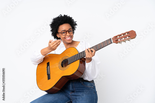 African american woman with guitar over isolated background inviting to come with hand. Happy that you came