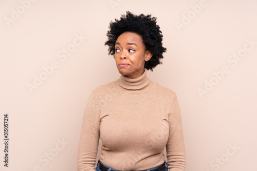 African american woman over isolated background making doubts gesture looking side