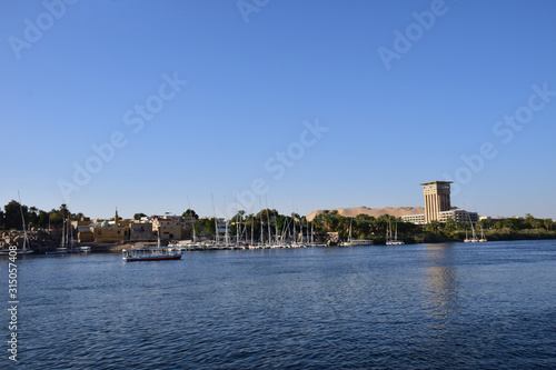 River Nile/ beautiful view for Aswan Egypt and Nubian Egyptian culture. sailing boat sailing in the River Nile and harbor with birds and local houses on the 2 sides 