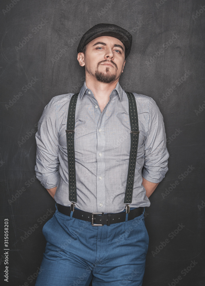 Handsome man in retro style with cap on blackboard background Handsome man in retro style with cap on blackboard background
