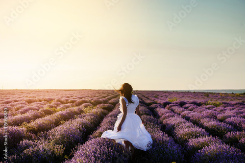 back view of a woman in white dress in lavander field