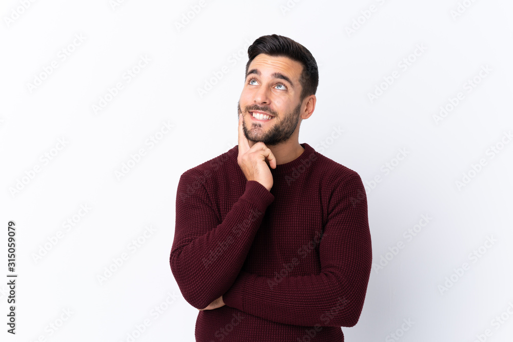 Young handsome man with beard over isolated white background thinking an idea while looking up Young handsome man with beard over isolated white background thinking an idea while looking up