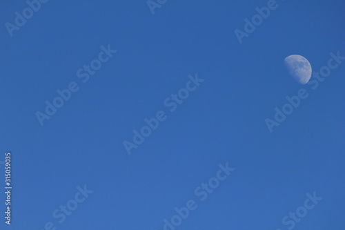 Blue sky and white half moon