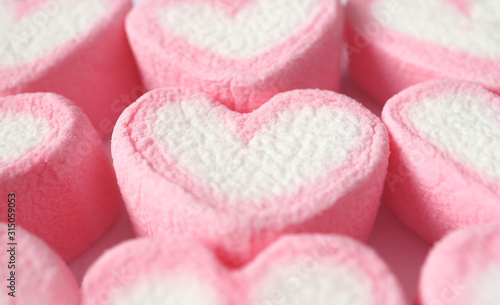 Closeup Row of Pastel Pink and White Heart Shaped Marshmallow Candies