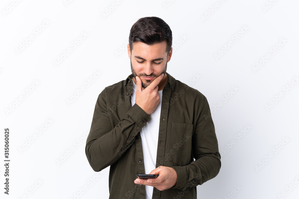 Young handsome man with beard over isolated white background thinking and sending a message Young handsome man with beard over isolated white background thinking and sending a message