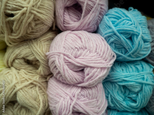 Different pastel color woolen threads for knitting. Colored balls of yarn.
