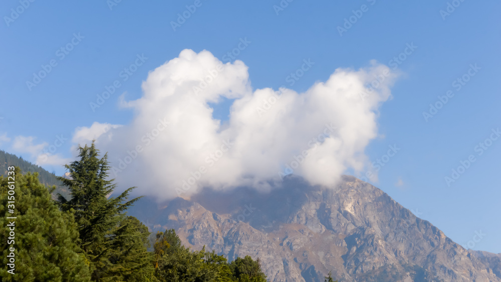 Dramatic white mist cloud floating over mountain. Blue sky backgrounds. Natural landscape background scenery. Copy space.