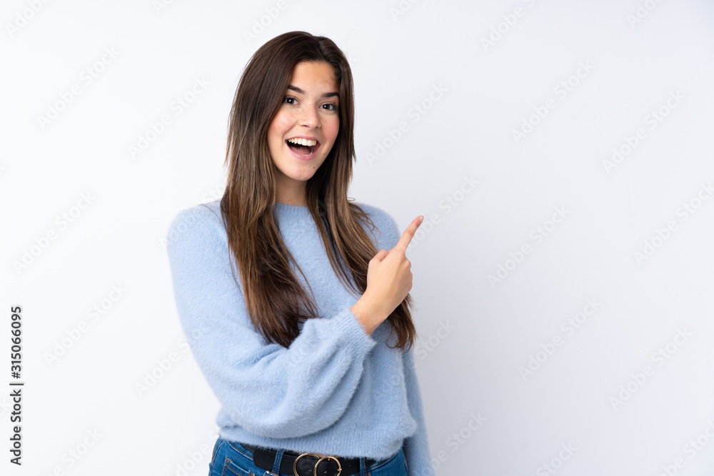 Teenager girl over isolated white background surprised and pointing side Teenager girl over isolated white background surprised and pointing side