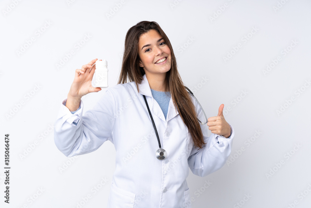 Teenager girl over isolated white background wearing a doctor gown and holding pills Teenager girl over isolated white background wearing a doctor gown and holding pills