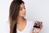 Teenager girl over isolated background with makeup palette