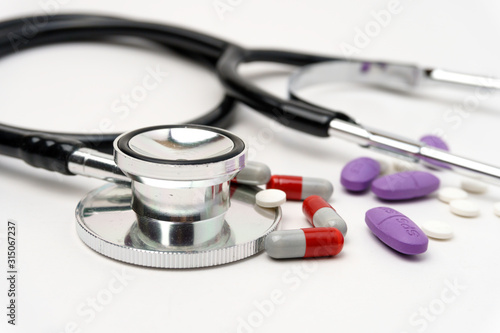 Medical, medicine stethoscope and pills on blue background. Health care or illness. Tablet or drug in hospital or pharmacy. Cardiology heart treatment. Medication prescription.