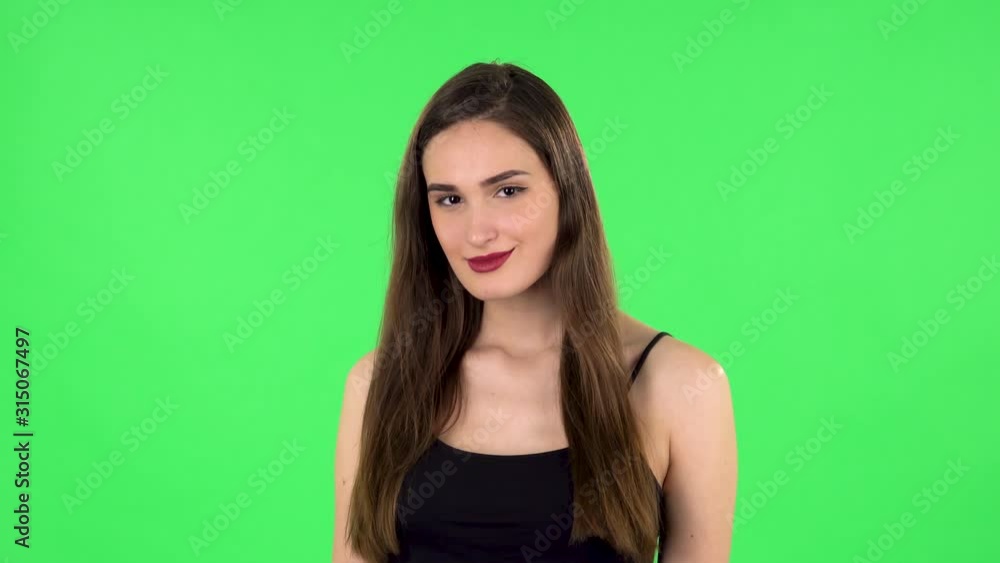 Woman coquettishly smiling while looking at camera. Green screen Woman coquettishly smiling while looking at camera. Green screen