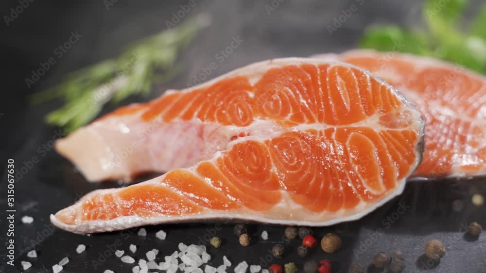 Raw, fresh salmon steak on a slate board and spices around. Raw salmon red fish. Cooking salmon, seafood. Raw, fresh salmon steak on a slate board and spices around. Raw salmon red fish. Cooking salmon, seafood.