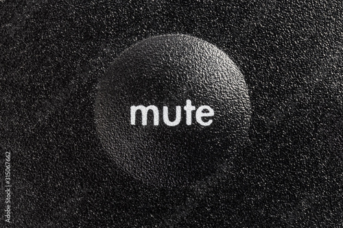 Macro close up photograph of mute button on audio controller.  