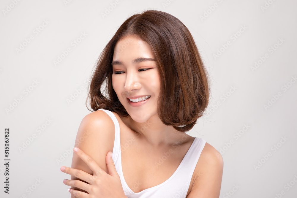 Beautiful Young Asian Woman with short hairs Touching Shoulder feeling so happy and cheerful with healthy Clean and Fresh skin,isolated on gray background,Beauty Cosmetology Concept Beautiful Young Asian Woman with short hairs Touching Shoulder feeling so happy and cheerful with healthy Clean and Fresh skin,isolated on gray background,Beauty Cosmetology Concept