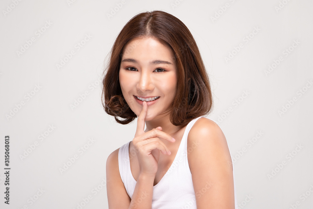 Beautiful Asian woman with short hair looking at camera making surprise and quiet sign forefinger touch on lips with clean and fresh skin,isolated on gray background,Beauty and Cosmetics Concept Beautiful Asian woman with short hair looking at camera making surprise and quiet sign forefinger touch on lips with clean and fresh skin,isolated on gray background,Beauty and Cosmetics Concept