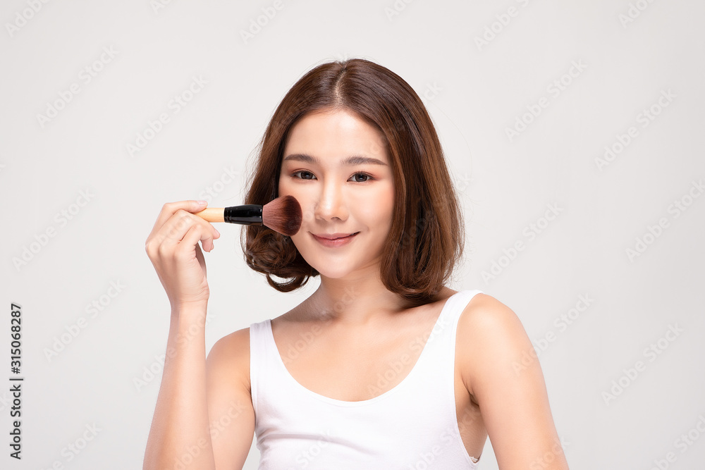 Beautiful Asian young woman smile and holding make up brush with healthy Clean and Fresh skin feeling so happiness and cheerful,Isolated on white background,Beauty Cosmetics Concept Beautiful Asian young woman smile and holding make up brush with healthy Clean and Fresh skin feeling so happiness and cheerful,Isolated on white background,Beauty Cosmetics Concept