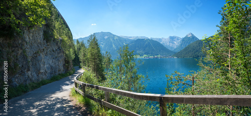 фотографія idyllic walkway and bike route along lake achensee east side in mountain landsca