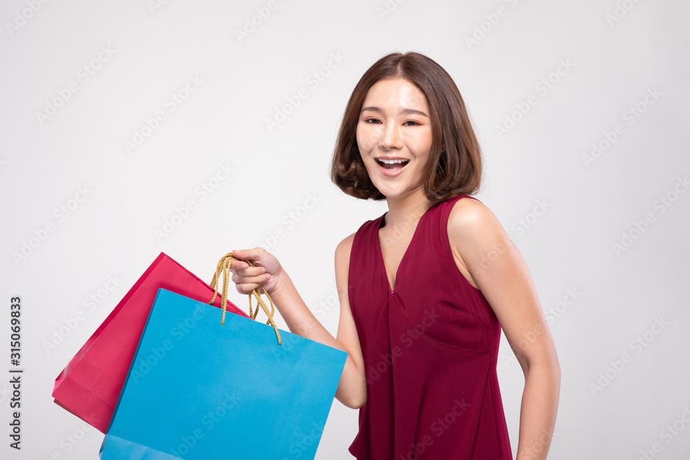 Shopping Asian woman with short hairs smile wearing red dress Holding Shopping bags,Cheerful and happiness emotional,Enjoy Shopping in black friday sale,Isolated on gray background,Shopping Concept Shopping Asian woman with short hairs smile wearing red dress Holding Shopping bags,Cheerful and happiness emotional,Enjoy Shopping in black friday sale,Isolated on gray background,Shopping Concept