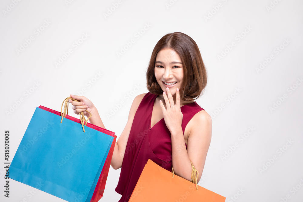 Shopping Asian woman with short hairs smile wearing red dress Holding Shopping bags,Cheerful and happiness emotional,Enjoy Shopping in black friday sale,Isolated on gray background,Shopping Concept Shopping Asian woman with short hairs smile wearing red dress Holding Shopping bags,Cheerful and happiness emotional,Enjoy Shopping in black friday sale,Isolated on gray background,Shopping Concept