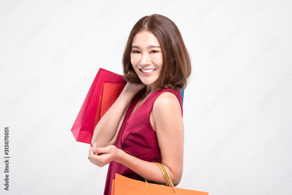 Shopping Asian woman with short hairs smile wearing red dress Holding Shopping bags,Cheerful and happiness emotional,Enjoy Shopping in black friday sale,Isolated on gray background,Shopping Concept Shopping Asian woman with short hairs smile wearing red dress Holding Shopping bags,Cheerful and happiness emotional,Enjoy Shopping in black friday sale,Isolated on gray background,Shopping Concept