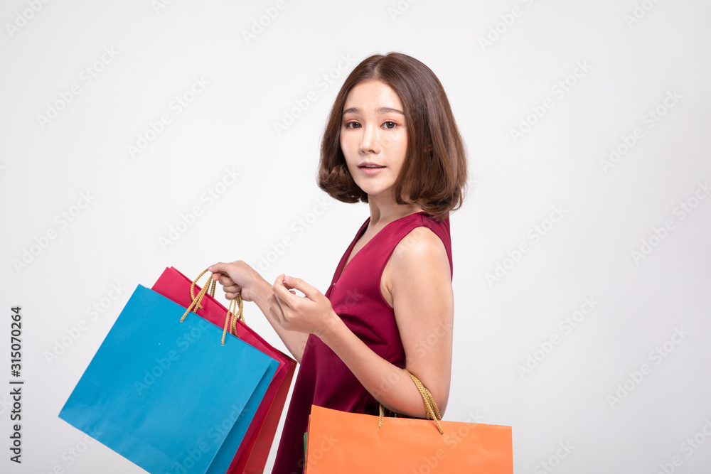 Shopping Asian woman with short hairs smile wearing red dress Holding Shopping bags,Cheerful and happiness emotional,Enjoy Shopping in black friday sale,Isolated on gray background,Shopping Concept Shopping Asian woman with short hairs smile wearing red dress Holding Shopping bags,Cheerful and happiness emotional,Enjoy Shopping in black friday sale,Isolated on gray background,Shopping Concept