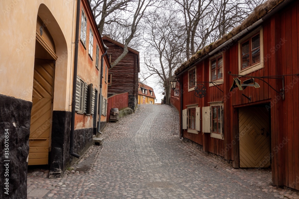 The street and buildings in the famous Skansen Museum in Stockholm which was the first one in the world with a generic Krog sign in the backgournd which is Tavern in English